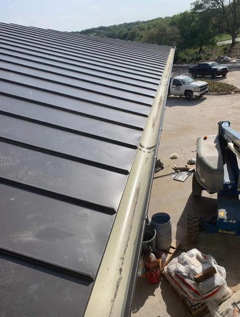 Standing seam panel and gutter detail on a metal roofing jobsite in Mattoon